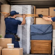 Professional movers securing furniture and boxes inside a moving truck before transport