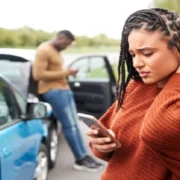 Car accident victim experiencing neck pain while documenting details at the accident scene in Las Vegas